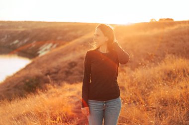 Gün batımında tarlada güzel bir kadının portresi.