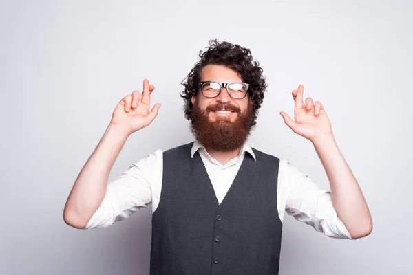 Portret mężczyzny z brodą w garniturze, trzymającego kciuki i wypowiadającego życzenie — Zdjęcie stockowe