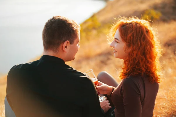 Bela jovem casal ter uma data ao ar livre durante o pôr do sol no verão — Fotografia de Stock