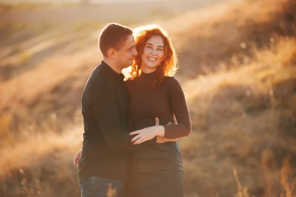 Foto de pareja alegre increíble abrazando al aire libre en la luz del sol durante la puesta del sol —  Fotos de Stock