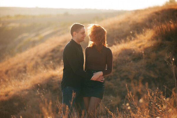 A photo of a couple in the field having a nice time together