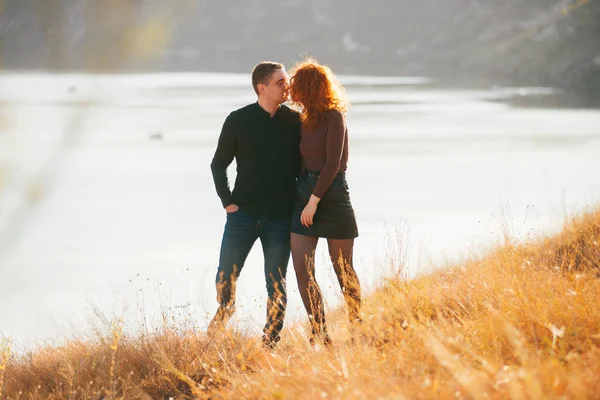 Una joven pareja caminando juntos cerca de un río — Foto de Stock