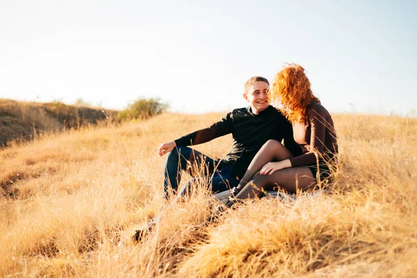 Una foto de una pareja sentada en el campo y hablando —  Fotos de Stock