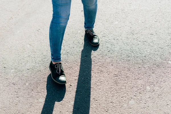 Gambe di una giovane donna in jeans che cammina sulla strada — Foto Stock
