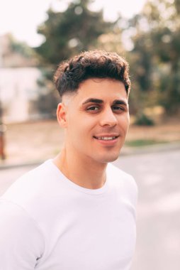 Kameraya gülümseyen genç bir adamın portresi.