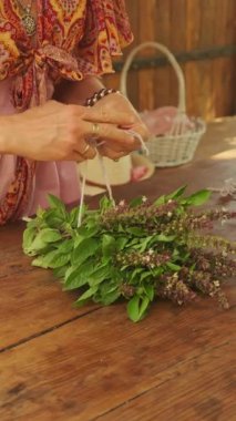 Yetenekli eller, kırsal bir zemine taze otlar ekleyen çarpıcı bir bitkisel düzen yaratıyor.