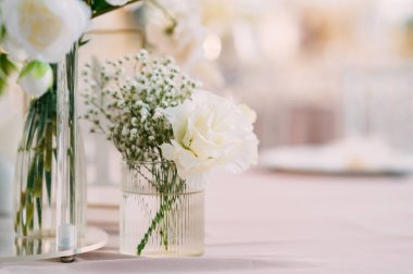 Muhteşem, zarif ve baş döndürücü beyaz çiçekler güzel bir vazoda sergileniyor. Düğünler ve özel günler için ideal.