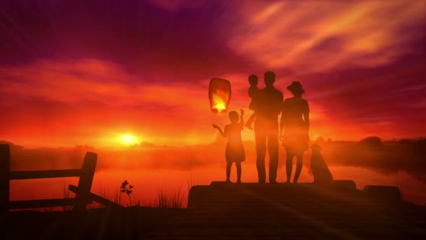 Familie zündet bei Sonnenuntergang eine chinesische Laterne an — Stockvideo