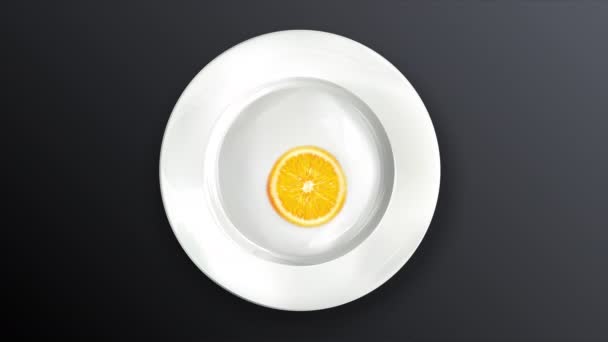 어두운 배경에 있는 흰 접시 위의 두 개의 오렌지색얇은 조각. — 비디오
