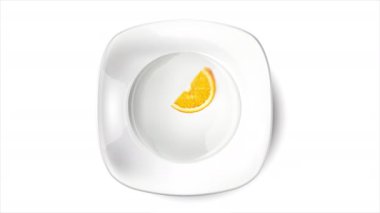 Dilimlenmiş turuncu beyaz bir plaka ve beyaz arka plan.