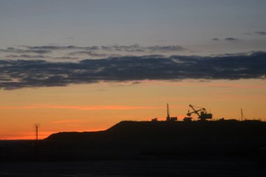 bir ekskavatör ve bir kamyon içinde belgili tanımlık geçmiş gün batımının ana hatları