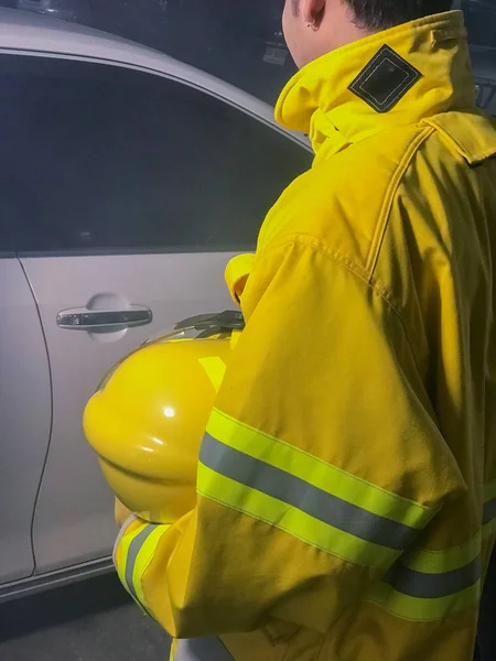 Bombeiros com terno amarelo segurando capacete tentar salvar a vida no carro — Fotografia de Stock