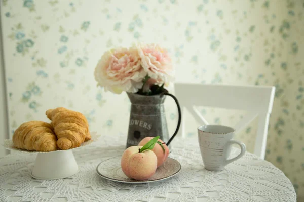 Food and flowers on a kitchen table in the morning. Concept of comfort, hospitality and cosiness.