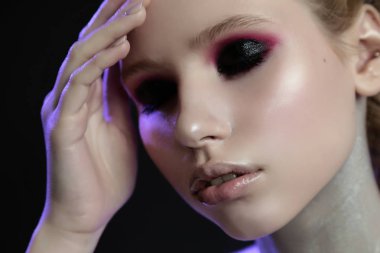 Duman gibi gözleri, yumuşak, mor ışığı olan güzel bir kızın stüdyo portresini kapat..