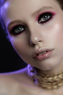 Duman gibi gözleri, yumuşak, mor ışığı olan güzel bir kızın stüdyo portresini kapat..