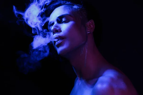 顔のアート バイオレットと青の光を持つ美しい若い男のスタジオの肖像画を閉じます 喫煙の概念 — ストック写真