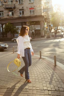 Güzel esmer bir kadının açık hava portresi, şık bir sokak fotoğrafı yürüyüşü, sokak modası