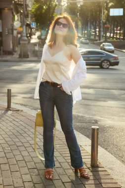 Güzel esmer bir kadının açık hava portresi, şık bir sokak fotoğrafı yürüyüşü, sokak modası