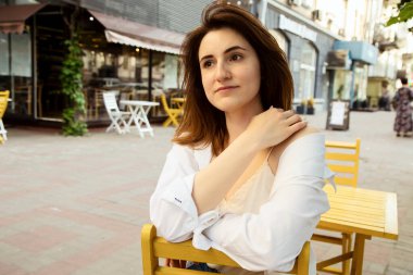 Güzel esmer bir kadının açık hava portresi, şık bir sokak fotoğrafı yürüyüşü, sokak modası