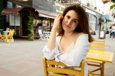 Güzel esmer bir kadının açık hava portresi, şık bir sokak fotoğrafı yürüyüşü, sokak modası