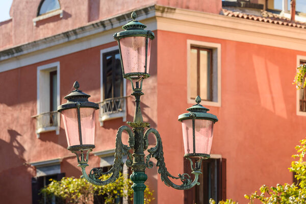 Ornate street lamp with pink glass in Venice, Italy.