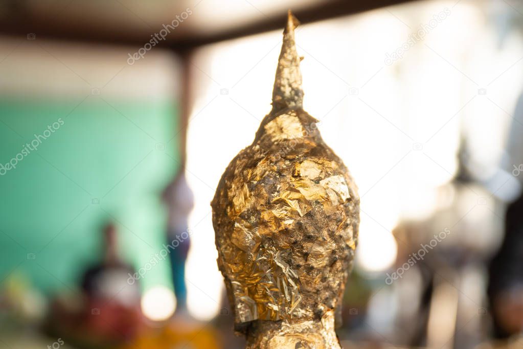 Gold leaf placed on a statue of Buddha by worshipers at the Wat Arun temple in Bangkok, Thailand.