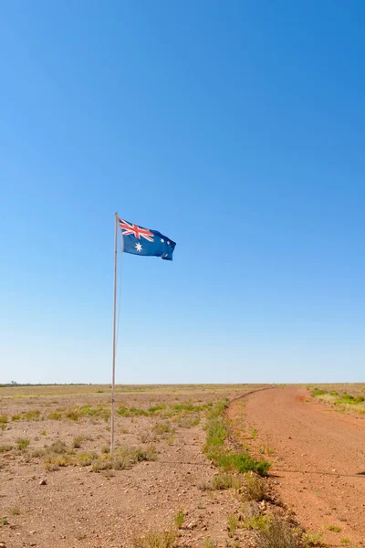 Australian flag flying in a desert landscape.