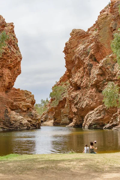 オーストラリア中部オーストラリア州の西マクドネル国立公園の水プールに座っている2人の身元不明の女性 — ストック写真