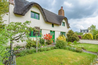 FORTINGALL, SCOTLAND - MAY 22, 2017:  Thatched roof cottages in the village of Fortingall, Perthshire, Scotland. clipart