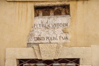 Verona'da bir kapının üzerindeki bir taşın üzerinde Latince metin.