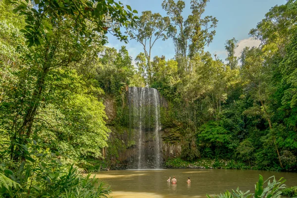 Millaa, Queensland, Avustralya: Kuzey Queensland, Avustralya'daki Atherton Tablelands'da Millaa Şelalesi'nin altındaki suda yıkanan insanlar.
