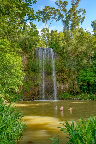 Millaa, Queensland, Avustralya: Kuzey Queensland, Avustralya'daki Atherton Tablelands'da Millaa Şelalesi'nin altındaki suda yıkanan insanlar.