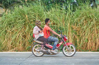 Mayıs 2020 'de Pathumthani, Tayland' da yüz maskesi takan bir adam ve kadın..
