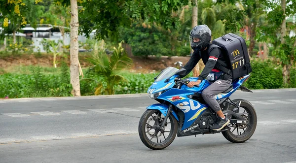  Nisan 2020 'de Pathumthani, Tayland' da çekilmiş bir motosikletli kurye..                                     