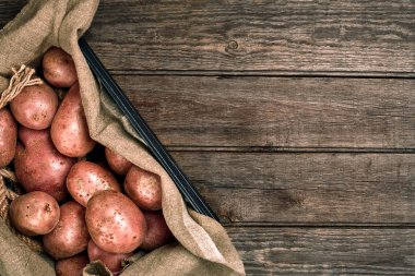 Çuvala ahşap masa üzerinde patates ile