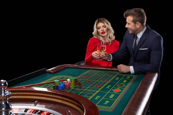 漂亮和穿着好的情侣在赌场玩轮盘赌 — 图库照片