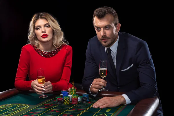 Bella e ben vestita coppia che gioca alla roulette nel casinò — Foto Stock