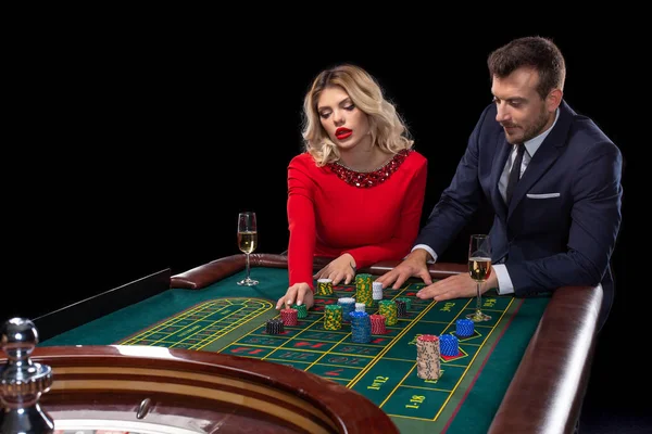 Krásný a dobře oblečený pár hraní rulety v kasinu — Stock fotografie
