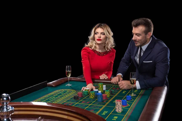 Beau couple bien habillé jouant à la roulette dans le casino — Photo