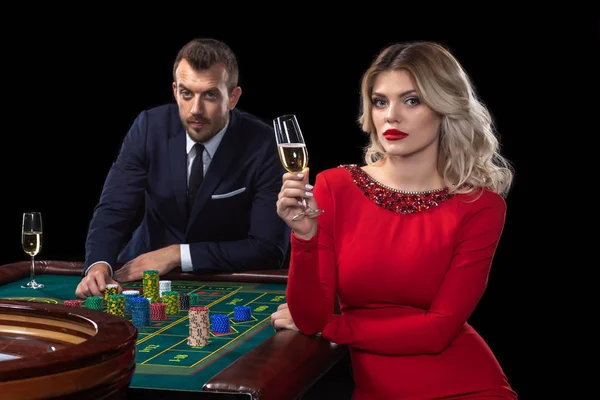 Une belle jeune femme et un homme sont assis à une table de roulette. Casino . — Photo