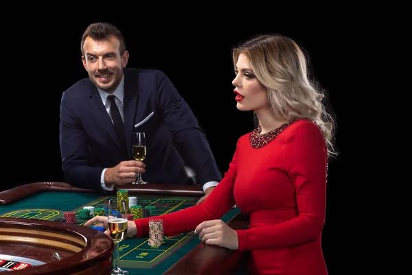Una bella giovane donna e un uomo sono seduti a un tavolo da roulette. Casino . — Foto Stock