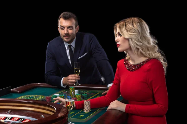 Une belle jeune femme et un homme sont assis à une table de roulette. Casino . — Photo