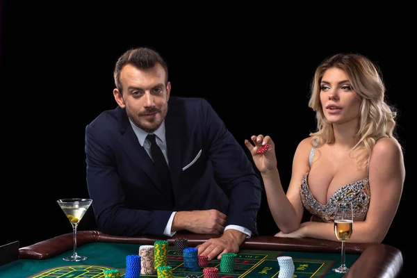 Pareja de apuestas en la mesa de ruleta en el casino — Foto de Stock