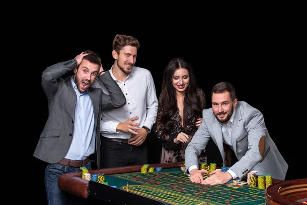 Upper class friends gambling in a casino.