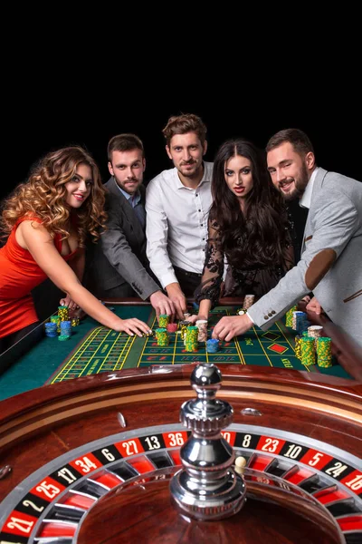 Group of young people behind roulette table in a casino — Stock Photo, Image