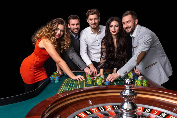 Gençlerin bir Casino rulet masasının arkasında grup — Stok fotoğraf