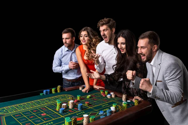 Grupo de jóvenes detrás de la mesa de ruleta en un casino —  Fotos de Stock
