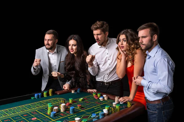 Gruppe junger Leute schaut aufgeregt auf Roulette — Stockfoto