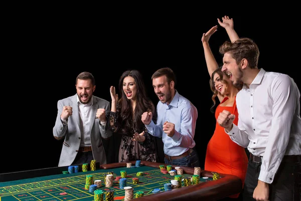 Group of young people looking excited at spinning roulette — Stock Photo, Image