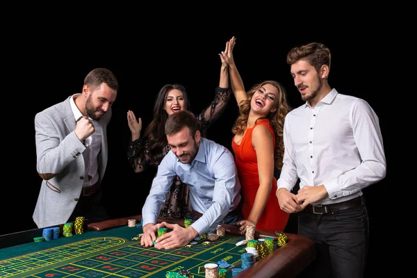 Erwachsenengruppe feiert Freund, der beim Roulette gewinnt — Stockfoto